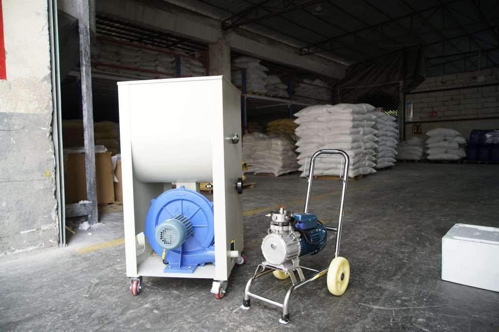Electrostatic flocking machine with a blower unit, ready to apply snow flocking powder to artificial trees.