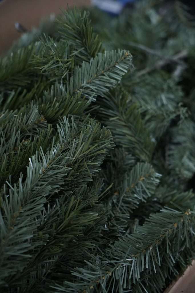 Close-up of realistic dark green PVC artificial Christmas tree needles, illustrating the finished quality achievable with high-grade raw material film for a manufacturer's buyer's guide.